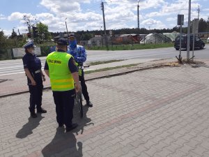 Policjanci i strażnicy przekazują kamizelki odblaskowe pieszym