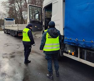 policjant i Funkcjonariusz Inspekcji Transportu Drogowego podchodzą do pojazdu ciężarowego
